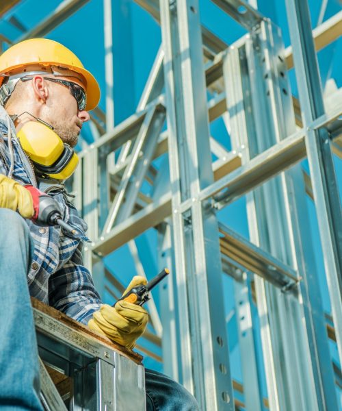 Professional Building Contractor in Front of Skeleton Frame