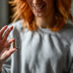 Young woman hand holding a hearing aid